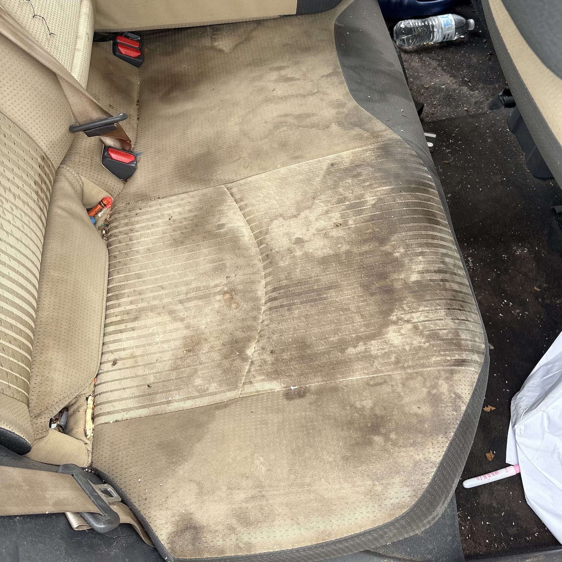 Stained cloth car seat before interior detailing at Shaq's Auto Spa